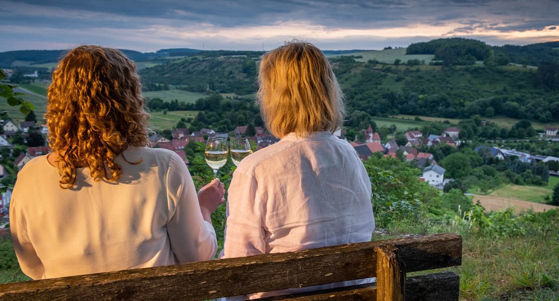 zwei Frauen auf einer Bank bei Daemmerung